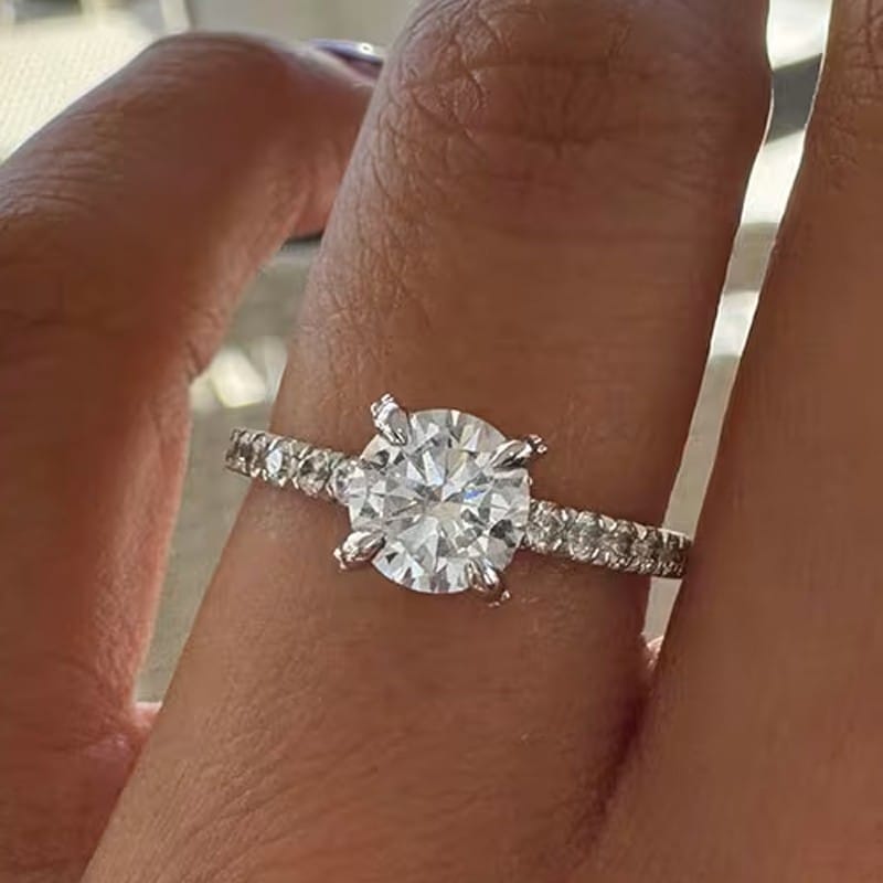 Brilliant Cut round diamond, with Fishtail set shoulders.